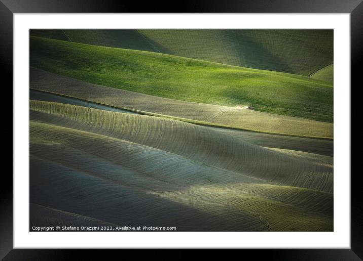 Tractor plowing the fields in Tuscany sunset. Vescona, Siena. Framed Mounted Print by Stefano Orazzini