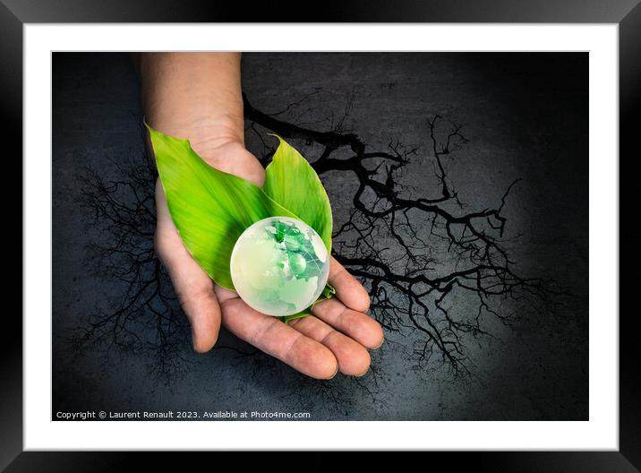 Human hands holding a green globe of planet Earth over leaves Framed Mounted Print by Laurent Renault