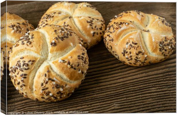 Whole wheat bread on wooden background. Bunch of kaiser rolls with sesame. Canvas Print by Lubos Chlubny