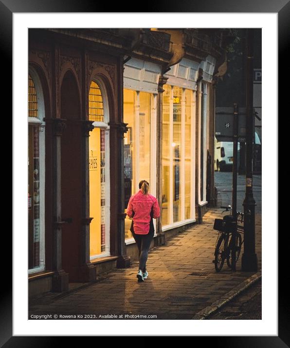 A jogger passing a warm shop front  Framed Mounted Print by Rowena Ko