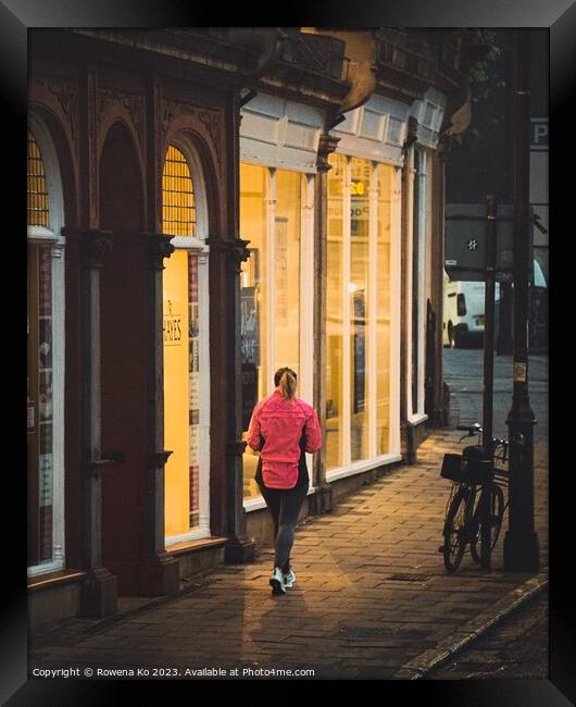 A jogger passing a warm shop front  Framed Print by Rowena Ko
