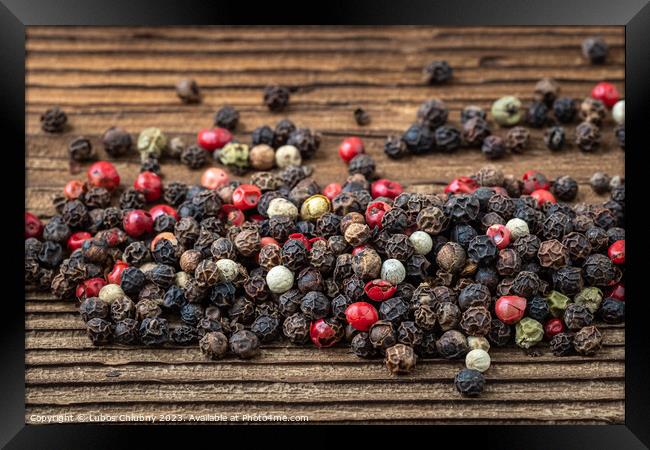 Peppercorns on dark rustic wooden background. Mix of different peppers Framed Print by Lubos Chlubny