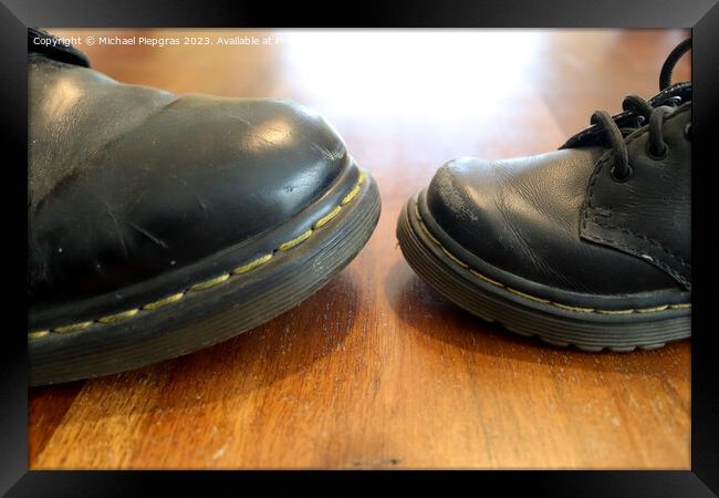 Big and small old black leather shoe on a wooden floor Framed Print by Michael Piepgras