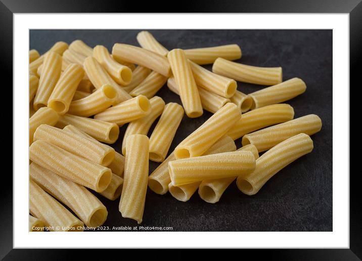 Raw italian penne rigate pasta isolated on black background Framed Mounted Print by Lubos Chlubny