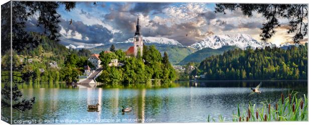 The Picturesque Island Church in Lake Bled with Alpine peaks beh Canvas Print by Paul E Williams