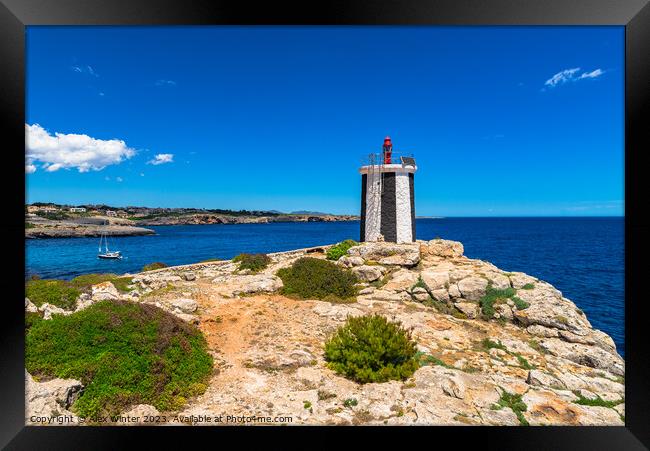 Beautiful view of lighthouse at the rocky coast Framed Print by Alex Winter