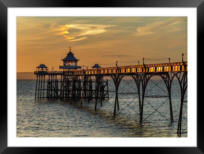 Clevedon Pier at sunset and sunlight reflecting onto the side panels Framed Mounted Print by Rory Hailes