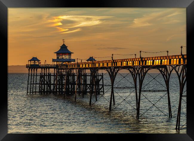Clevedon Pier at sunset and sunlight reflecting onto the side panels Framed Print by Rory Hailes