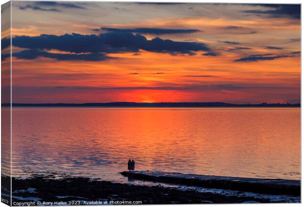 Sunset over the Bristol channel with reddish reflection in the sky and reflecting onto the sea Canvas Print by Rory Hailes