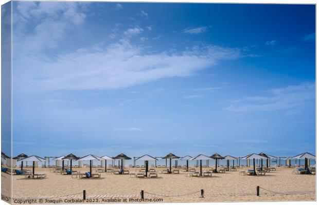 Beach with no one in the Algarve, in spring, with modern umbrell Canvas Print by Joaquin Corbalan