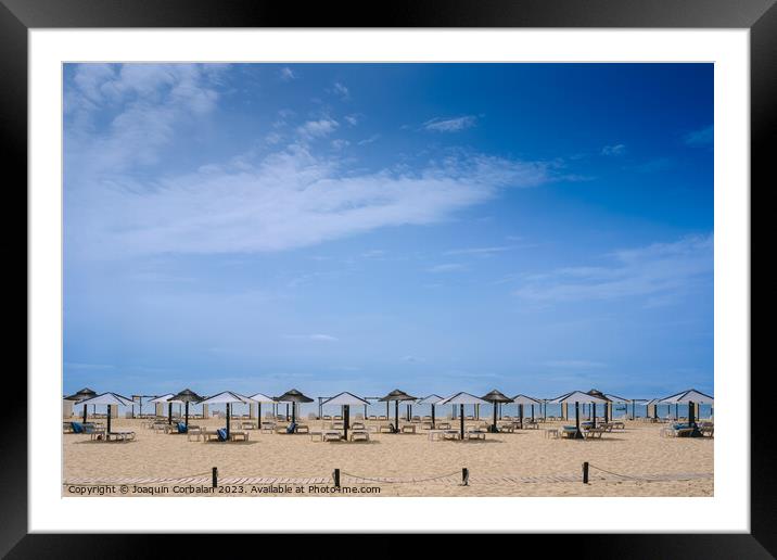 Beach with no one in the Algarve, in spring, with modern umbrell Framed Mounted Print by Joaquin Corbalan