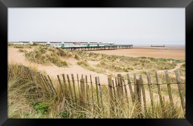 Beach fence in front of St Anne's Pier Framed Print by Jason Wells