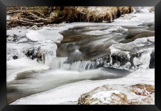 A flowing stream under snowy conditions  Framed Print by Nick Jenkins