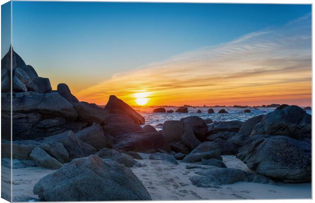Sunset over rocks on the beach at Meneham Canvas Print by Helen Hotson