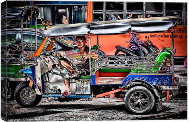 Tuk tuk driver reading the newspaper Canvas Print by Kevin Hellon