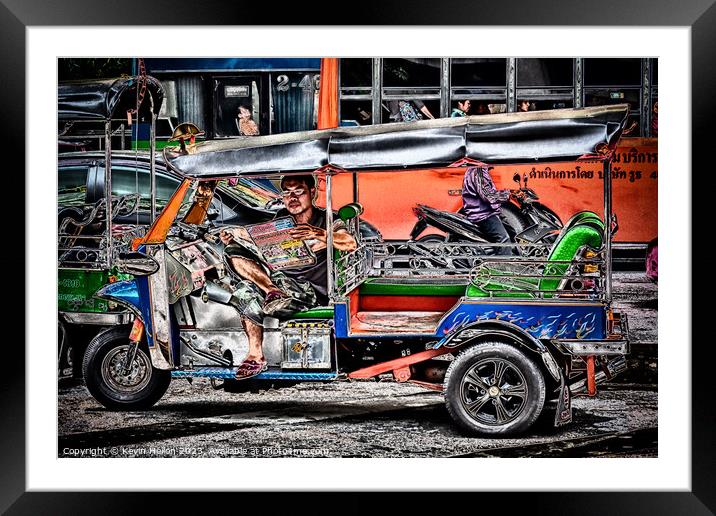 Tuk tuk driver reading the newspaper Framed Mounted Print by Kevin Hellon