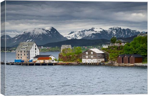 Wooden Buildings and Mountains in Alesund Norway Canvas Print by Martyn Arnold