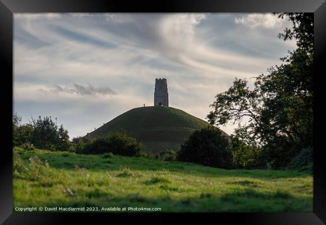 A large green field with trees in the background with Glastonbury Tor in the background Framed Print by David Macdiarmid