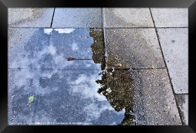 Sidewalk reflections from a rain  puddle Framed Print by Kevin Plunkett