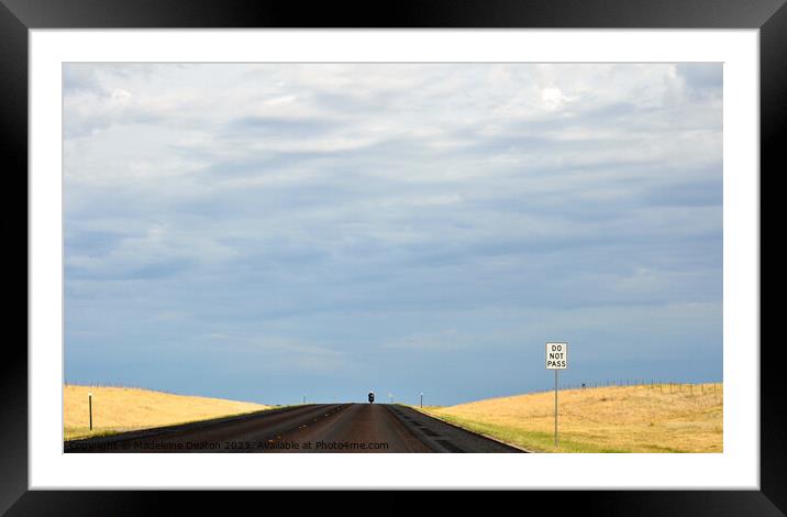 Lone biker on an empty rural road with 'Do Not Pass' sign in the foreground Framed Mounted Print by Madeleine Deaton