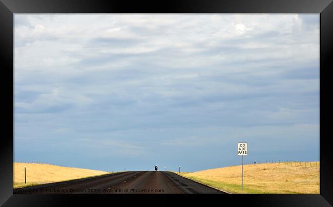 Lone biker on an empty rural road with 'Do Not Pass' sign in the foreground Framed Print by Madeleine Deaton