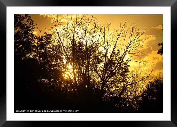 Sun's Twilight Dance Behind Verdant Silhouettes Framed Mounted Print by Ken Oliver