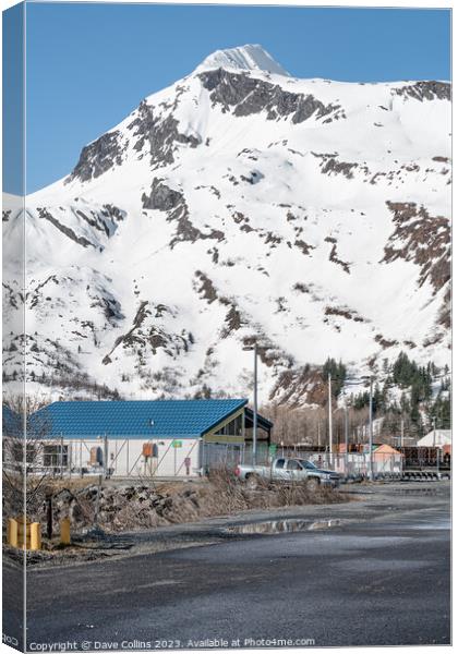 Industrial buildings in the town with snow a covered mountain in the background, Whittier, Alaska, USA Canvas Print by Dave Collins