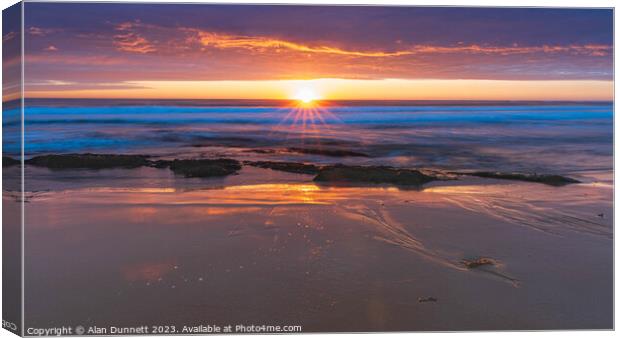 Dawn's Embrace Over Coastal Waters Canvas Print by Alan Dunnett
