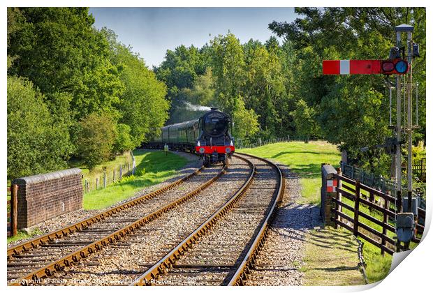 The Flying Scotsman steam train traveling down train tracks near a forest Print by John Gilham