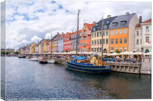 Copenhagen, Denmark - August 8, 2023: The most famous canal in Copenhagen with its quaint colorful houses overlooking the docked sailboats. Canvas Print by Joaquin Corbalan