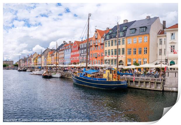 Copenhagen, Denmark - August 8, 2023: The most famous canal in Copenhagen with its quaint colorful houses overlooking the docked sailboats. Print by Joaquin Corbalan