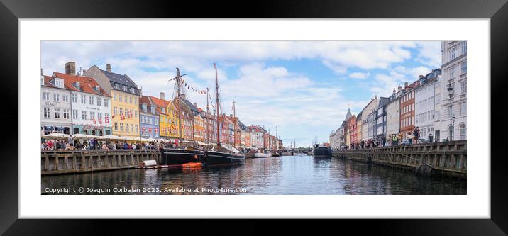 Copenhagen, Denmark - August 8, 2023: The most famous canal in Copenhagen with its quaint colorful houses overlooking the docked sailboats. Framed Mounted Print by Joaquin Corbalan