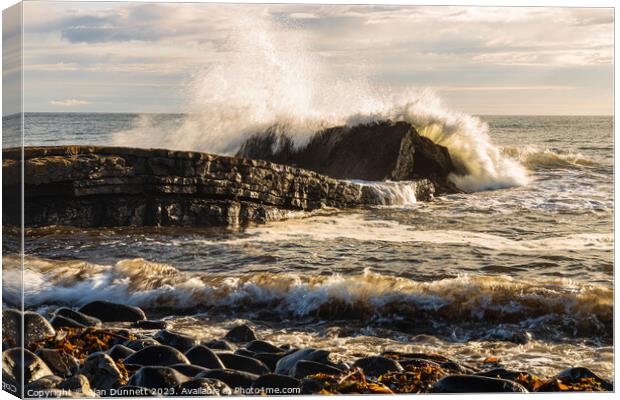 Dunstanburgh big splash at Greymare Rock Canvas Print by Alan Dunnett