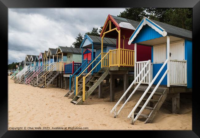 Colourful beach huts Framed Print by Clive Wells
