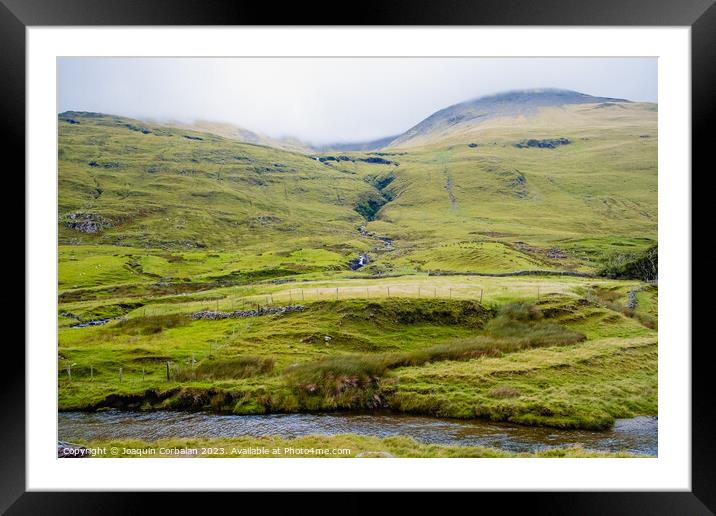 Mist covers the top of a hill covered in fresh green grass, typical Irish pastures. Framed Mounted Print by Joaquin Corbalan