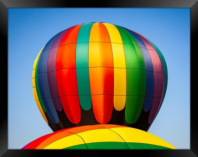 Colorful hot air balloon rising above another with Framed Print by Steve Heap