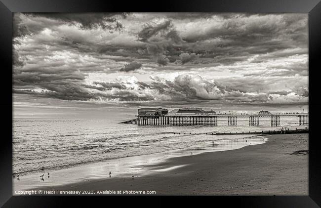 Stormy Clouds over the Pier Framed Print by Heidi Hennessey