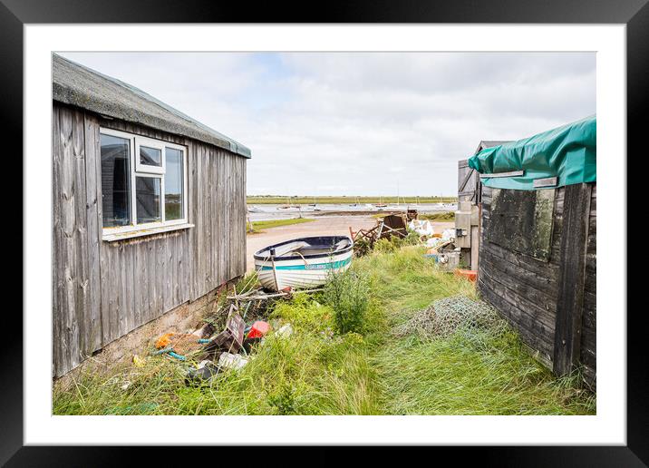 Fishing boat between fishing huts at Brancaster Staithe Framed Mounted Print by Jason Wells