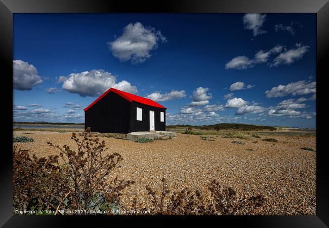 A Red Roofed Corrugated Iron Hut on the shingle at Framed Print by John Gilham