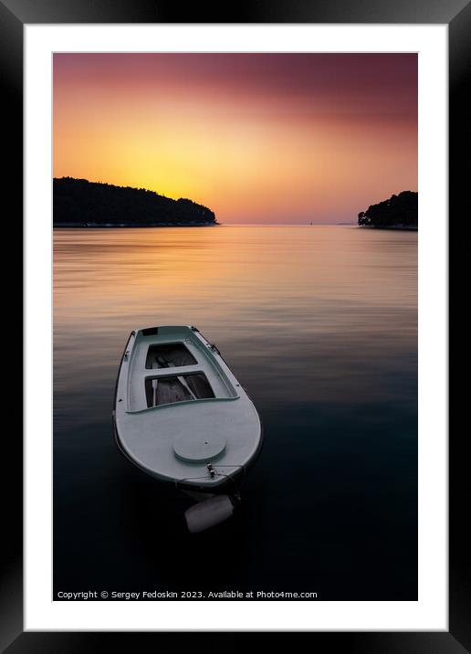 Fishing boat in a sea, near coast. Sunset time. Framed Mounted Print by Sergey Fedoskin