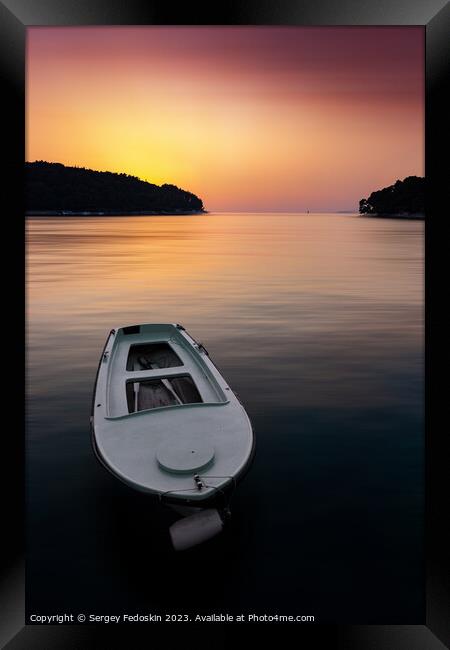 Fishing boat in a sea, near coast. Sunset time. Framed Print by Sergey Fedoskin