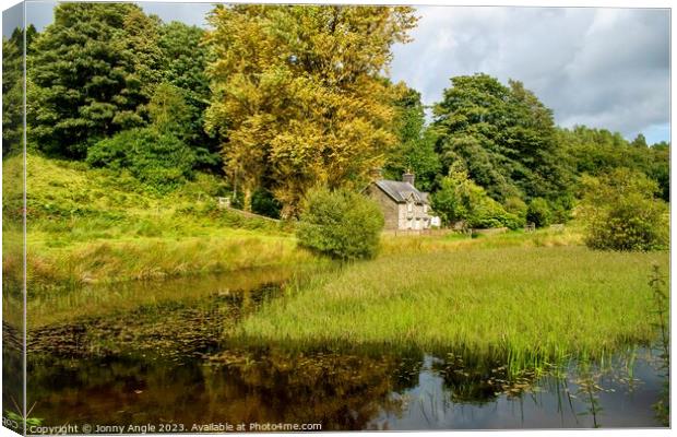 Romantic cottage in trees with water reflecting light  Canvas Print by Jonny Angle