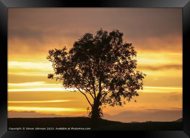 A sunset over a body of water Framed Print by Simon Johnson