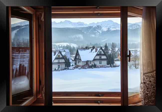 Beautiful view from an open window to a winter vil Framed Print by Olga Peddi