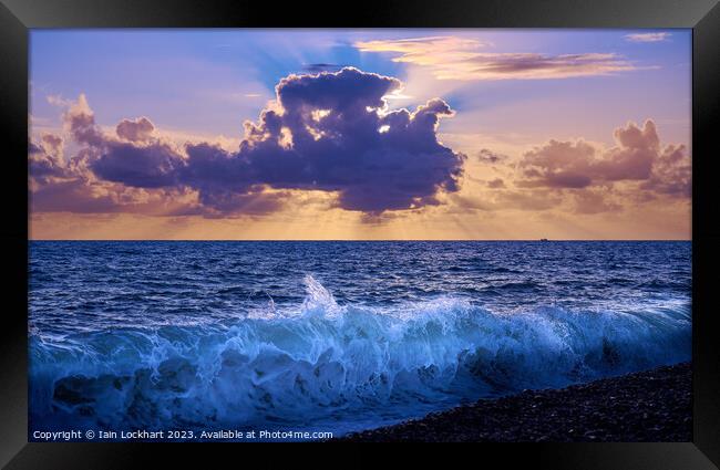 Sunset from Brighton beach with light glistening on the sea spray Framed Print by Iain Lockhart