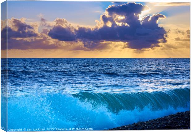 Sunset from Brighton beach with light glistening on rolling waves Canvas Print by Iain Lockhart