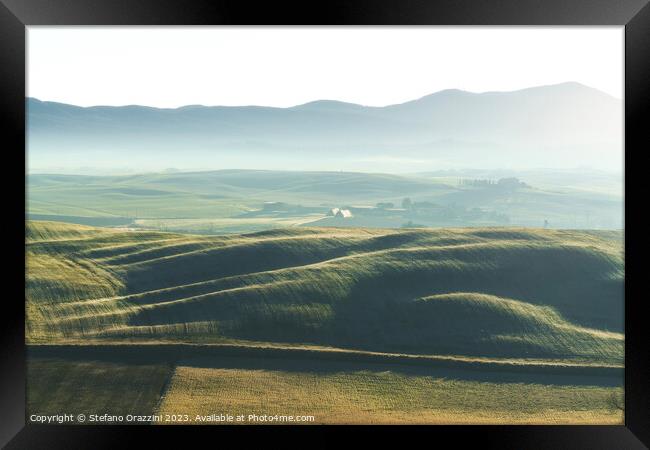 Foggy morning in Tuscany. Rolling hills at sunrise. Val d'Orcia Framed Print by Stefano Orazzini