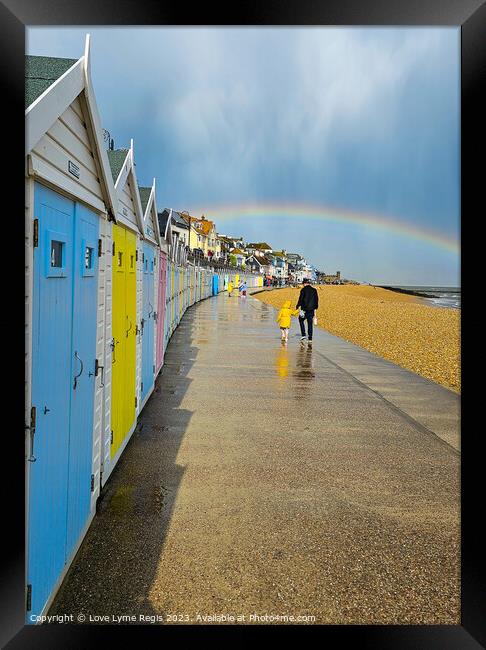 Pastel coloured beach huts Lyme Regis with a rainbow Framed Print by Love Lyme Regis