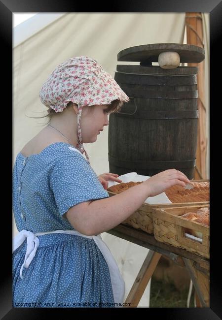 Woman baking bread, Civil War Reenactment; girl at counter Framed Print by Arun 