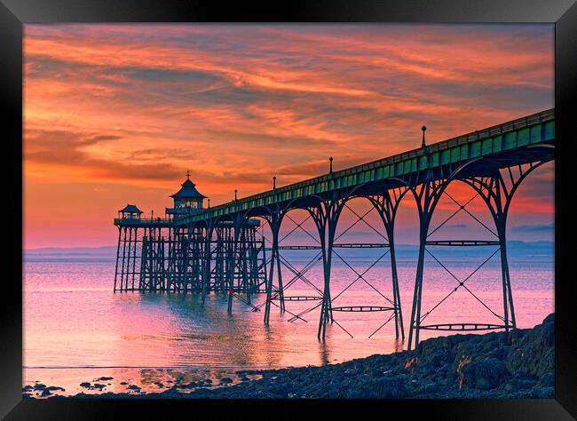Clevedon Pier at sunset on a calm evening with cloud and blue sky above Framed Print by Rory Hailes